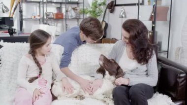 Anne ve çocuk evde beslenen hayvan spaniel okşayarak