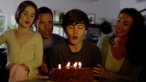 Menino apaga velas no bolo de aniversário — Vídeo de Stock