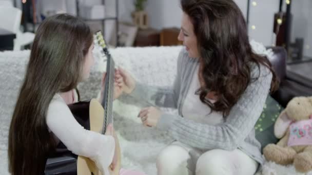 Mutter und Tochter verbringen Zeit miteinander und spielen Gitarre — Stockvideo
