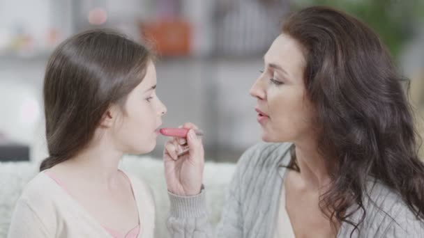 Attraktive Frau bringt ihrer Tochter bei, wie man Lippenstift aufsetzt — Stockvideo