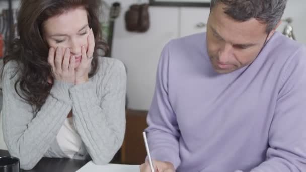 Привлекательная пара садится, чтобы разобраться со своими домашними счетами — стоковое видео