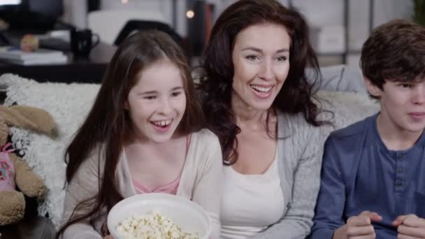 Familia feliz viendo deportes en la TV y derramando palomitas por todas partes — Vídeo de stock