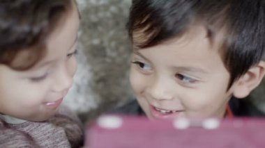 iki sevimli çocuk bir mobil oyun konsolunda oynamak