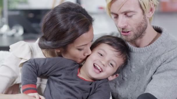 Муж и жена отдыхают и обнимаются со своим маленьким сыном — стоковое видео