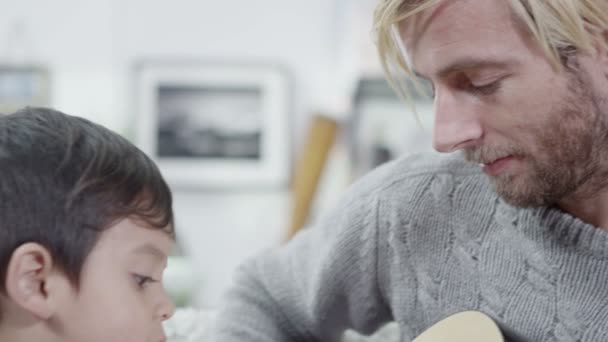 父は彼の若い息子のため、ギターを弾く — ストック動画