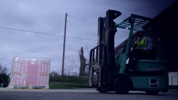 Pracovník skladu řídí vysokozdvižný vozík do skladu — Stock video