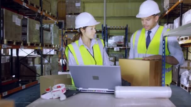 Deux employés d'entrepôt discutent stock 