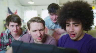 genç erkek arkadaşlar bir tablet bilgisayar ile rahatlatıcı mutlu rahat grubu