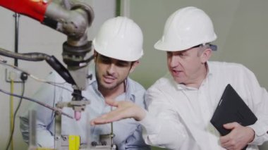 Olgun erkek Fabrika Müdürü genç adam için makine nasıl çalıştığını açıklar