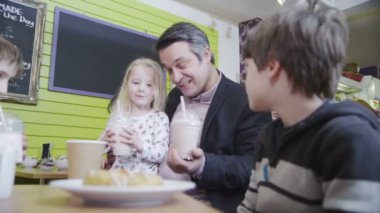 sevimli küçük erkek ve kız bir kafede kendi milkshakes paylaşmaktan keyif alıyorum.