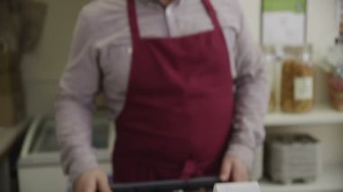 dükkâncı tezgahın arkasındaki bir kredi kartı ile ödeme bir müşteri alır.