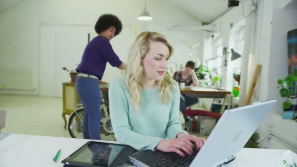 Glückliche junge Studenten, die mit Technologie in einem gemeinsamen Studienraum zusammenarbeiten — Stockvideo