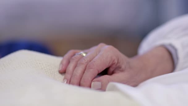 Держать пациента за руку на больничной койке — стоковое видео