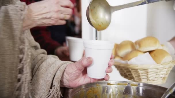 Alimentar os famintos - mãos ávidas tomam sopa e pão — Vídeo de Stock