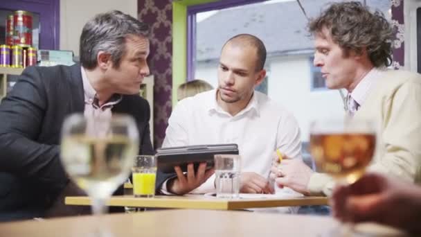 Three cheerful businessmen in casual meeting in a cafe — Stock Video