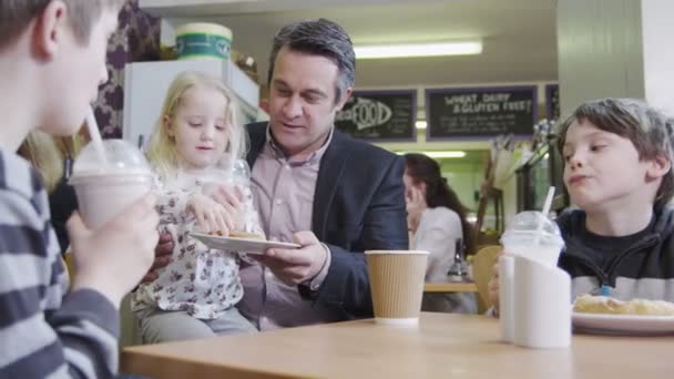 Família afetuosa feliz desfrutando de lanches e bebidas em um café — Vídeo de Stock