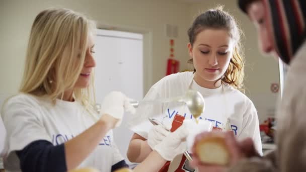 Ehrenamtliche Helfer in der Suppenküche helfen Obdachlosen — Stockvideo