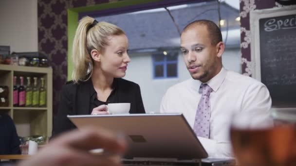 Aantrekkelijke jonge professionals in informele vergadering in een koffieshop — Stockvideo