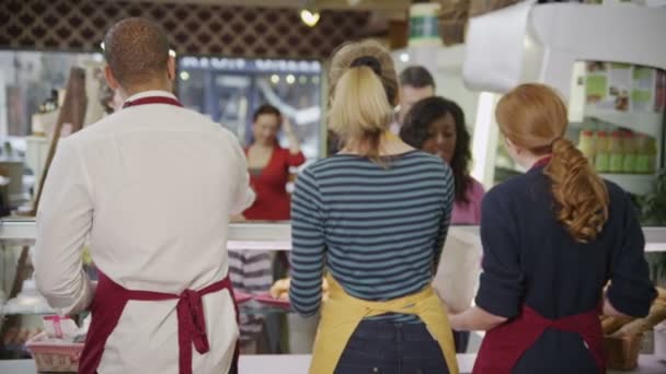 Des clients heureux servis par un personnel amical au comptoir de boulangerie — Video