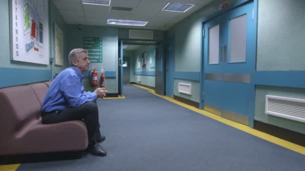 Беспокойный человек в больнице ждет новостей — стоковое видео