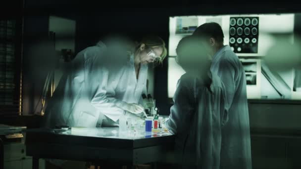 Sötét laboratóriumban dolgozó tudósok — Stock videók