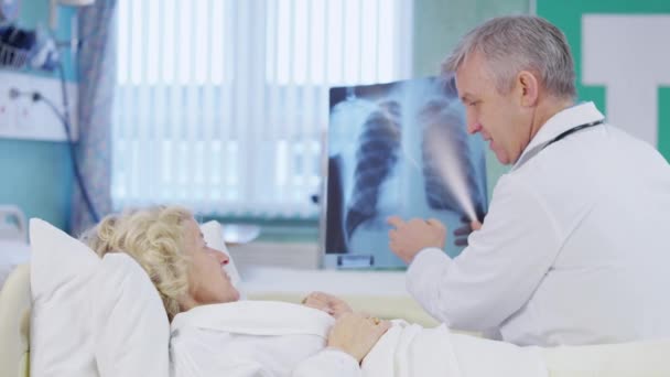 Doctor discussing x-ray results with patient — Stock Video