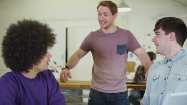 Jóvenes estudiantes masculinos charlando y trabajando juntos con la tecnología — Vídeo de stock