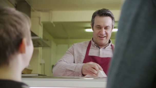 Amable tendero masculino que sirve a los clientes con pasteles frescos — Vídeos de Stock