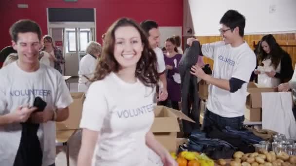 Voluntarios de caridad clasificando a través de bienes donados — Vídeos de Stock