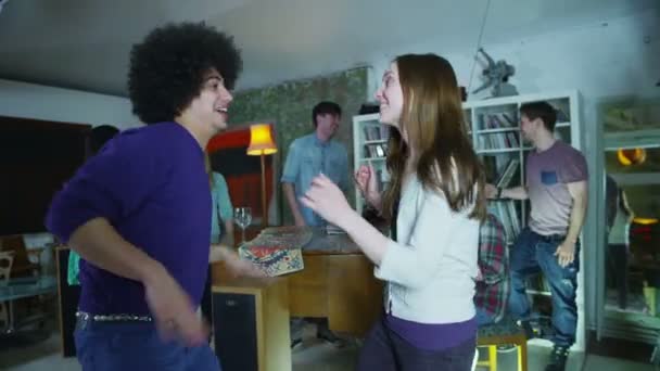 Šťastné a bezstarostné skupina mladých přátel, pitím a tancem na house party — Stock video