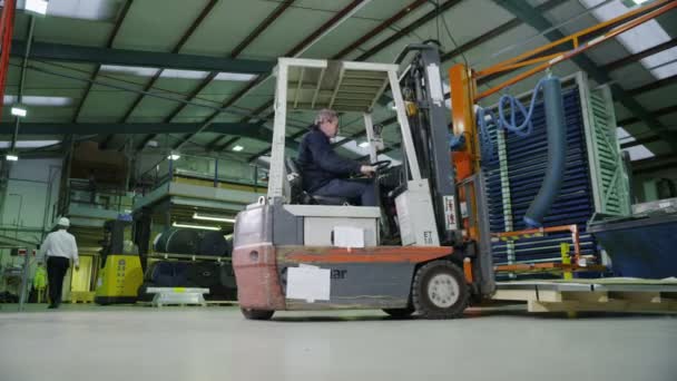 Team von fleißigen Lagerarbeitern hebt und bewegt leere Holzpaletten — Stockvideo