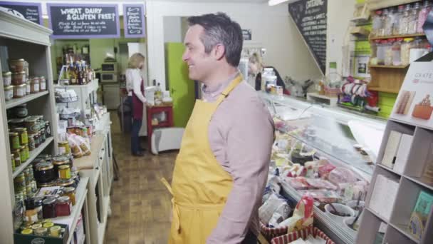 Portrait of a happy male shopkeeper in a delicatessen or food store — Stock Video