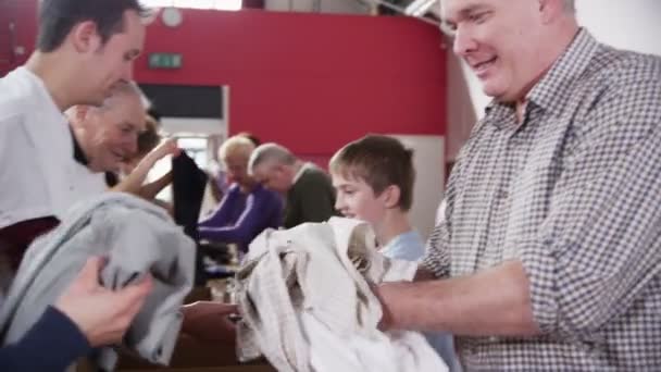 Liefdadigheid werknemers accepteren donaties van voedsel en kleding uit leden van de Gemeenschap — Stockvideo