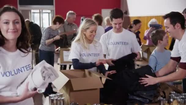 Charity volunteers sorting through donated goods — Stock Video