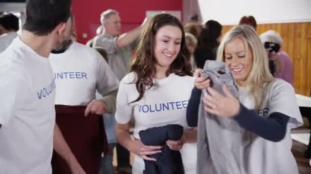 Caridade voluntários triagem através de bens doados — Vídeo de Stock