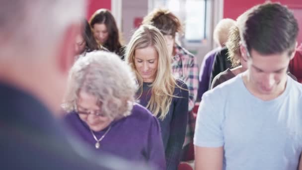 Church group bow their heads to pray — Stock Video