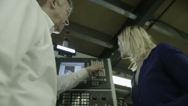 Volwassen man laat zien hoe u fabriek machines — Stockvideo