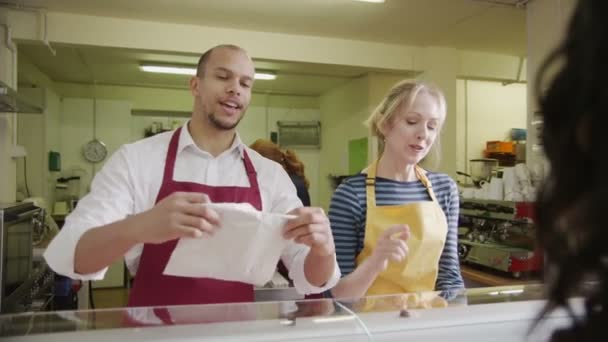 Personnel amical servant les clients avec un sourire au comptoir de boulangerie — Video
