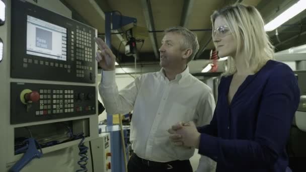 Homme mûr démontre comment utiliser des machines d'usine 