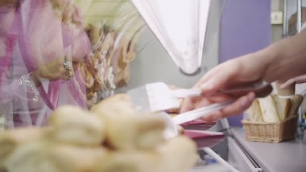 Mujer joven comprando café y una pastelería fresca en un café o panadería . — Vídeos de Stock