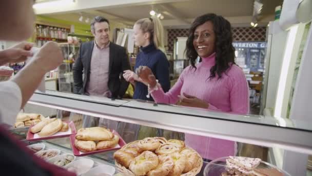 Vriendelijke medewerkers bedienen van klanten met een glimlach op de bakkerij-teller — Stockvideo