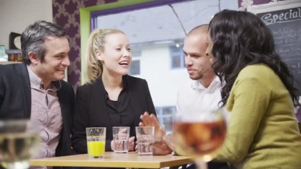 Fröhliche Gruppe von Freunden oder Geschäftskollegen plaudert zusammen in einem kleinen Café — Stockvideo