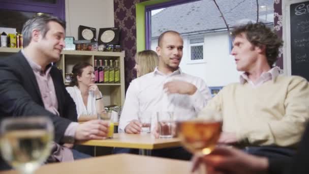 Three cheerful casual businessmen chatting together in a small cafe or wine bar — Stock Video