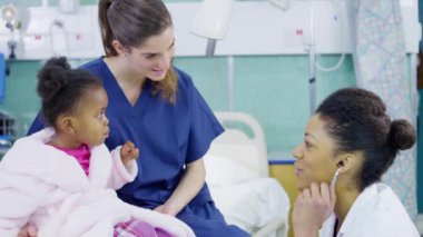 kadın doktor stetoskop bir hastane, sevimli küçük kız incelemek için kullanır..
