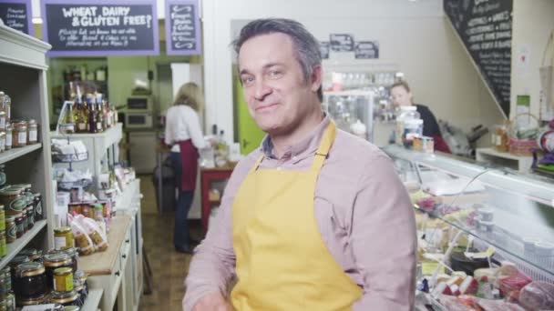 Portrait of a happy male shopkeeper in a delicatessen or food store — Stock Video