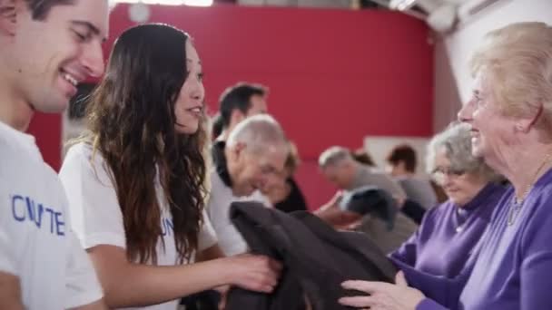 Voluntários aceitam doações de alimentos e roupas de membros da comunidade — Vídeo de Stock