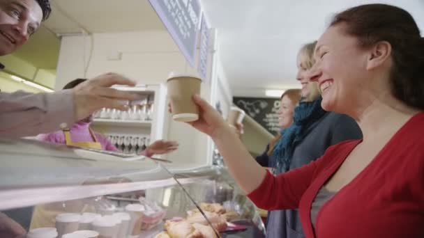 Vriendelijke mannelijke en vrouwelijke Barista's bedienen van klanten in een koffieshop — Stockvideo