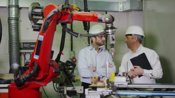 Olgun erkek Fabrika Müdürü genç adam için makine nasıl çalıştığını açıklar — Stok video