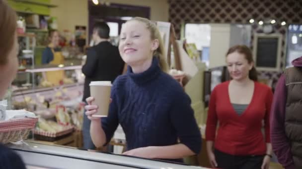 Щасливі клієнти купують каву та свіжі випічки в кафе — стокове відео