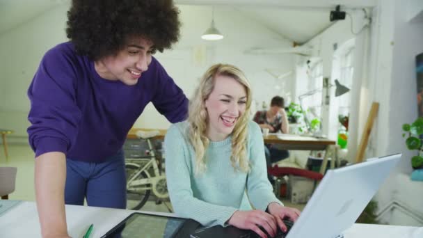 Glückliche junge Studenten, die mit Technologie in einem gemeinsamen Studienraum zusammenarbeiten — Stockvideo
